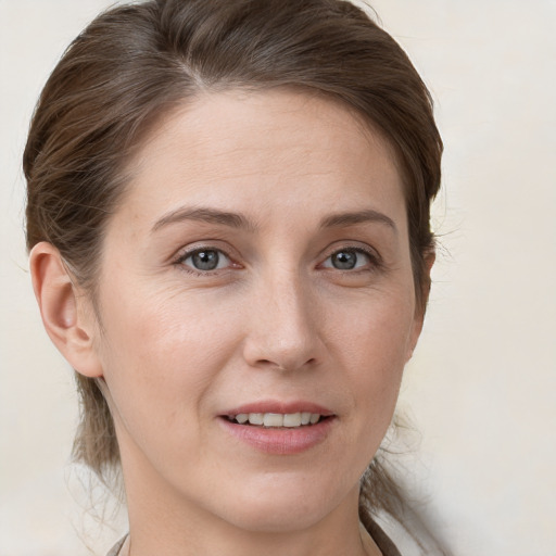 Joyful white young-adult female with medium  brown hair and grey eyes