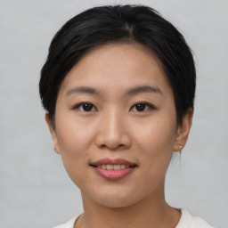 Joyful asian young-adult female with short  brown hair and brown eyes