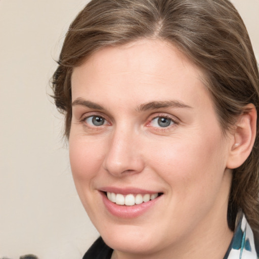 Joyful white young-adult female with medium  brown hair and blue eyes