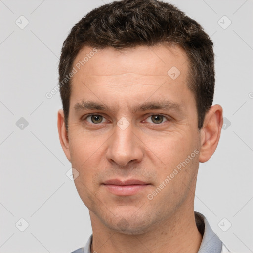 Joyful white young-adult male with short  brown hair and grey eyes