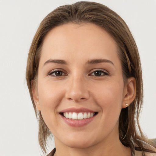 Joyful white young-adult female with medium  brown hair and grey eyes