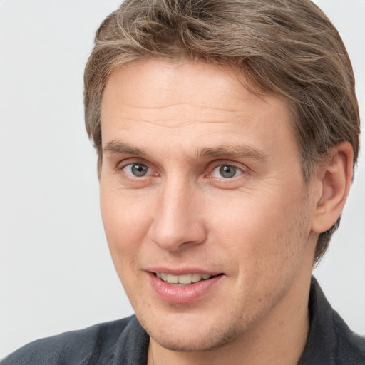 Joyful white adult male with short  brown hair and grey eyes