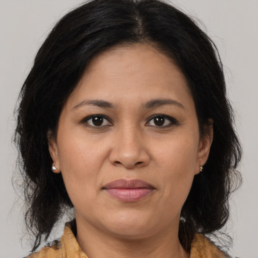 Joyful latino adult female with medium  brown hair and brown eyes