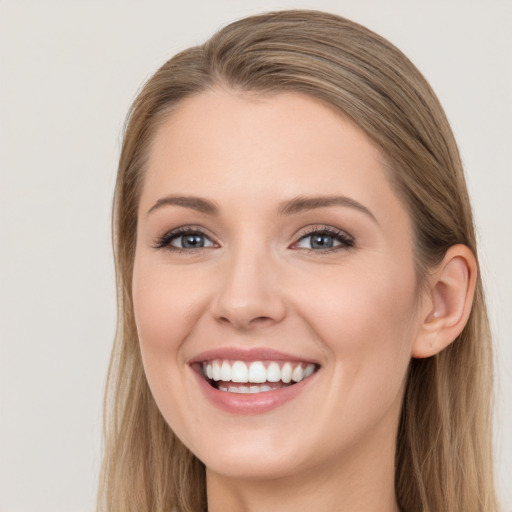 Joyful white young-adult female with long  brown hair and blue eyes