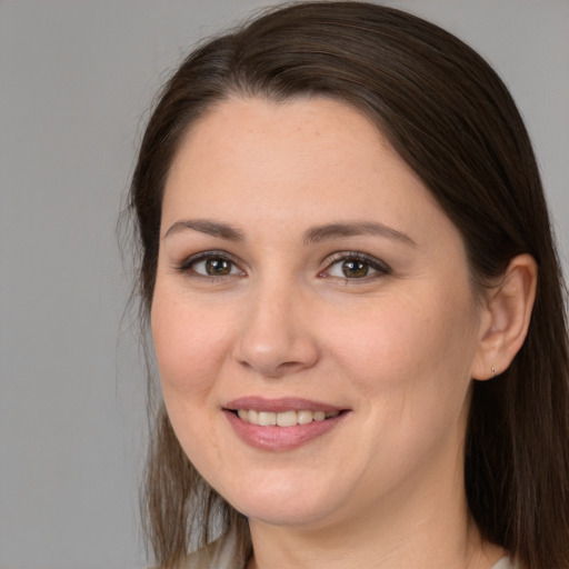 Joyful white young-adult female with long  brown hair and brown eyes