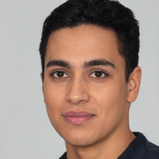 Joyful latino young-adult male with short  black hair and brown eyes