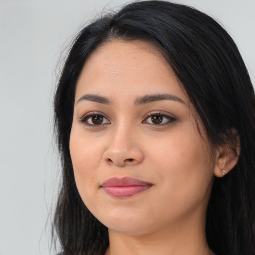 Joyful latino young-adult female with long  black hair and brown eyes