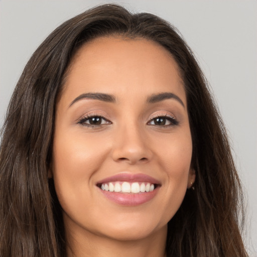 Joyful white young-adult female with long  brown hair and brown eyes