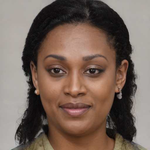 Joyful black young-adult female with long  black hair and brown eyes