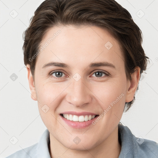 Joyful white young-adult female with short  brown hair and grey eyes