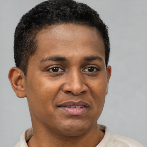 Joyful latino young-adult male with short  brown hair and brown eyes