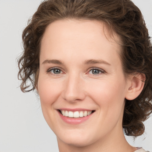 Joyful white young-adult female with medium  brown hair and green eyes