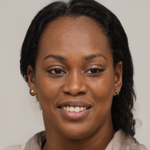 Joyful black adult female with medium  brown hair and brown eyes