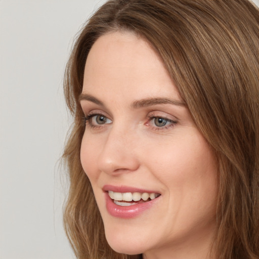 Joyful white young-adult female with long  brown hair and green eyes