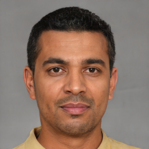 Joyful latino adult male with short  black hair and brown eyes