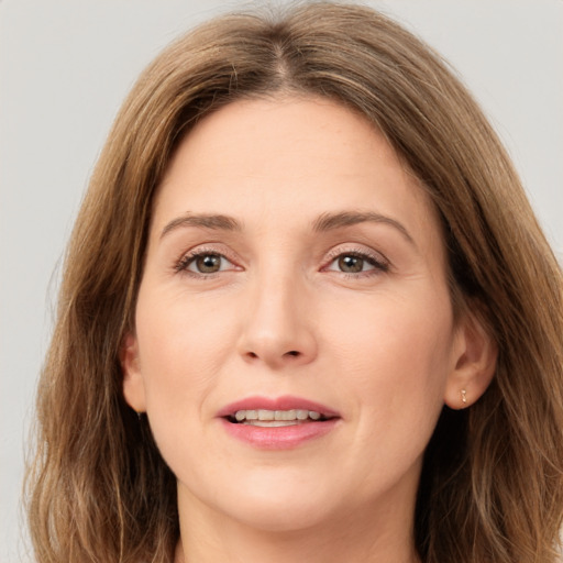 Joyful white young-adult female with long  brown hair and green eyes