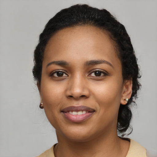 Joyful black young-adult female with long  brown hair and brown eyes
