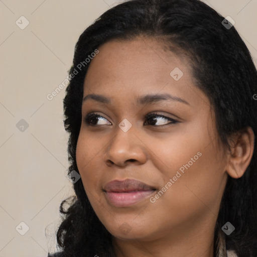 Joyful black young-adult female with long  black hair and brown eyes