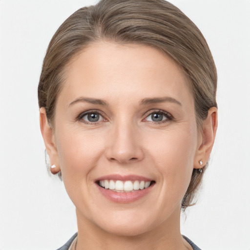 Joyful white young-adult female with medium  brown hair and grey eyes