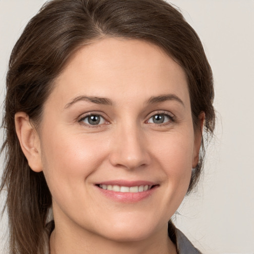 Joyful white young-adult female with medium  brown hair and grey eyes