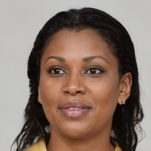 Joyful black young-adult female with long  black hair and brown eyes