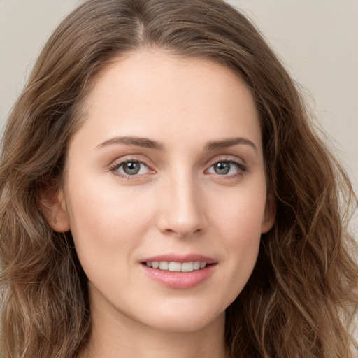 Joyful white young-adult female with long  brown hair and green eyes