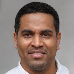 Joyful latino adult male with short  black hair and brown eyes