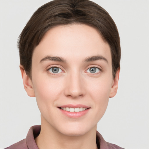 Joyful white young-adult female with short  brown hair and grey eyes