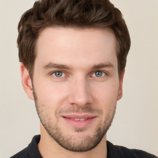 Joyful white young-adult male with short  brown hair and grey eyes