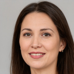 Joyful white adult female with long  brown hair and brown eyes