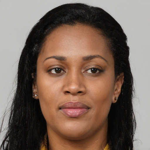 Joyful black young-adult female with long  brown hair and brown eyes