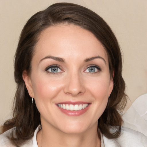 Joyful white young-adult female with medium  brown hair and blue eyes