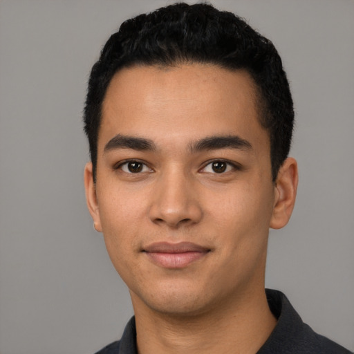 Joyful latino young-adult male with short  black hair and brown eyes