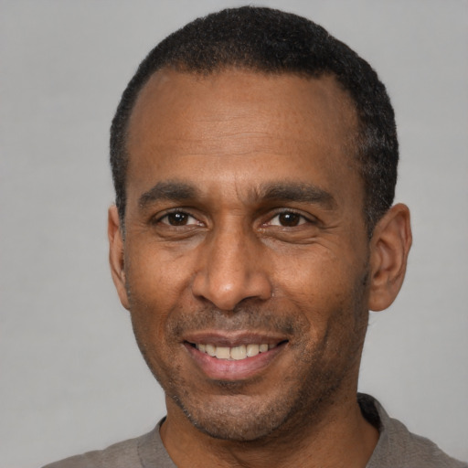 Joyful latino adult male with short  black hair and brown eyes