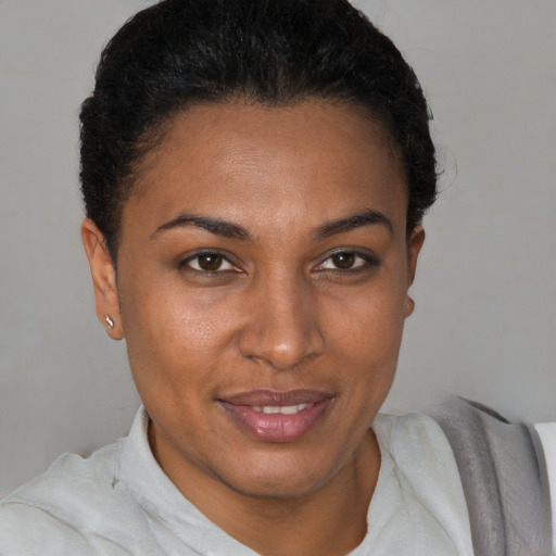 Joyful black young-adult female with short  brown hair and brown eyes