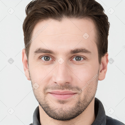 Joyful white young-adult male with short  brown hair and grey eyes