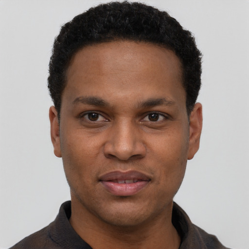 Joyful black young-adult male with short  black hair and brown eyes