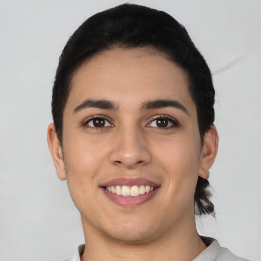 Joyful latino young-adult female with short  black hair and brown eyes