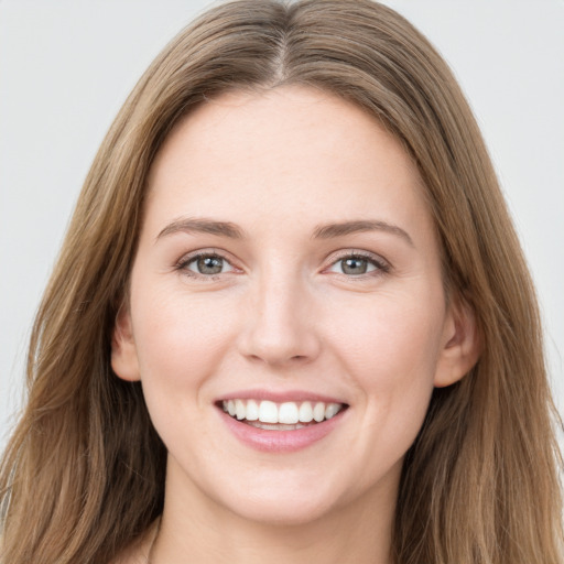 Joyful white young-adult female with long  brown hair and grey eyes