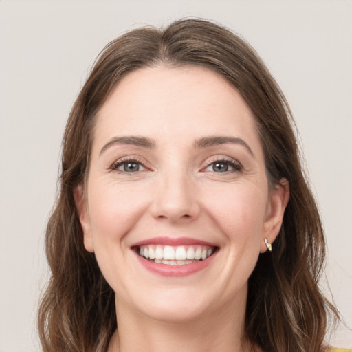 Joyful white young-adult female with long  brown hair and grey eyes