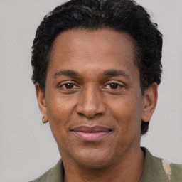 Joyful black adult male with short  black hair and brown eyes