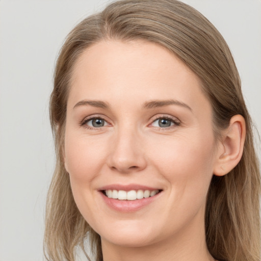 Joyful white young-adult female with long  brown hair and grey eyes