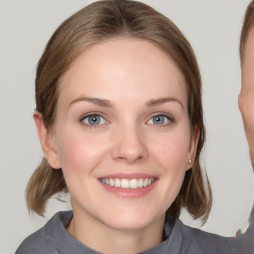 Joyful white young-adult female with medium  brown hair and blue eyes