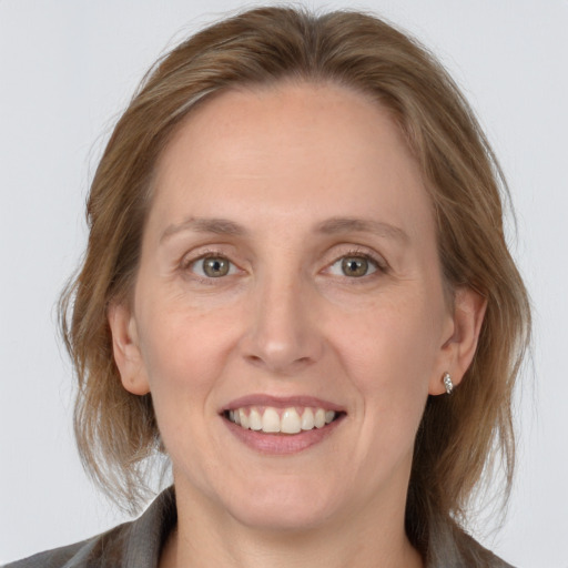 Joyful white adult female with medium  brown hair and grey eyes