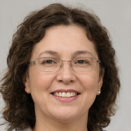 Joyful white adult female with medium  brown hair and green eyes