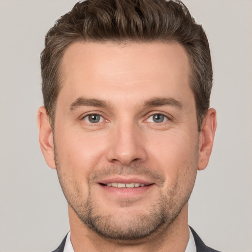 Joyful white young-adult male with short  brown hair and grey eyes