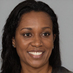 Joyful black adult female with long  brown hair and brown eyes