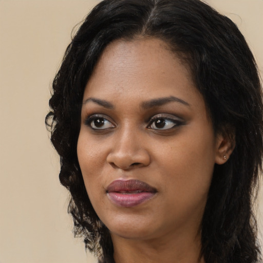 Joyful black young-adult female with long  black hair and brown eyes