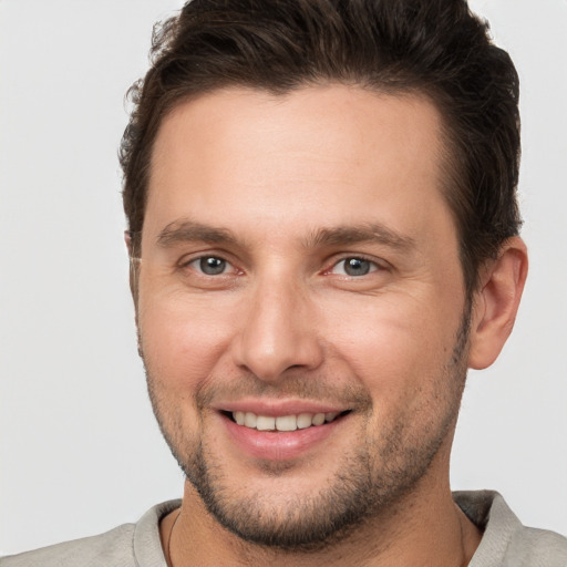 Joyful white young-adult male with short  brown hair and brown eyes