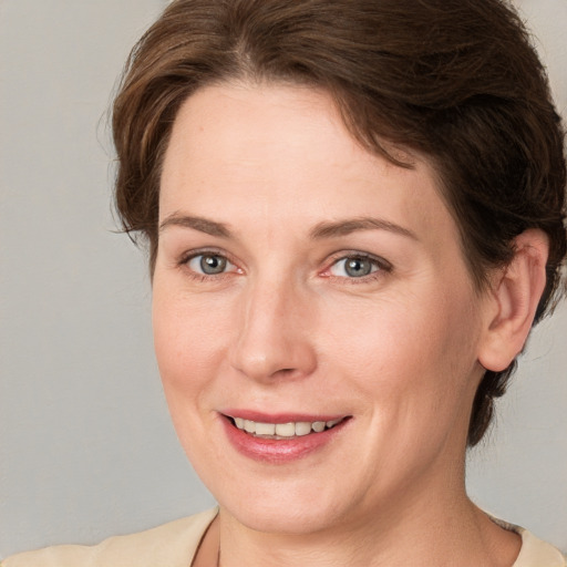 Joyful white adult female with medium  brown hair and grey eyes